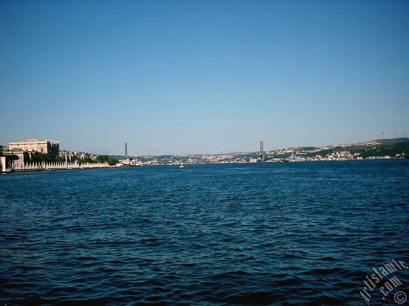 View of the Dolmabahce Palace, Bosphorus Bridge and Uskudar coast from a park at Dolmabahce shore in Istanbul city of Turkey.
