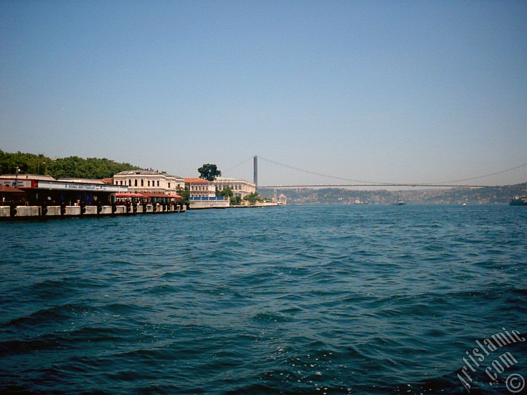 View of the Ciragan Palace and the Bosphorus Bridge from the shore of Besiktas district of Istanbul city in Turkey.
