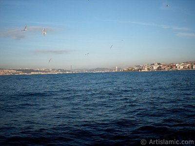 View of Bosphorus Bridge, Uskudar coast and Kiz Kulesi (Maiden`s Tower) from the Bosphorus in Istanbul city of Turkey. (The picture was taken by Artislamic.com in 2004.)