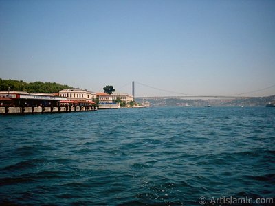 View of the Ciragan Palace and the Bosphorus Bridge from the shore of Besiktas district of Istanbul city in Turkey. (The picture was taken by Artislamic.com in 2004.)