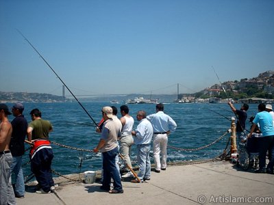 View of fishing people and on the horizon Bosphorus Bridge from Uskudar shore of Istanbul city of Turkey. (The picture was taken by Artislamic.com in 2004.)