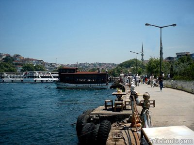 View of the shore, a fisher boat and Mihrimah Sultan Mosque`s minarets in Uskudar district of Istanbul city of Turkey. (The picture was taken by Artislamic.com in 2004.)