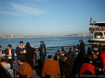 View of people eating sandwich with fish from the shore of Eminonu in Istanbul city of Turkey. (The picture was taken by Artislamic.com in 2004.)