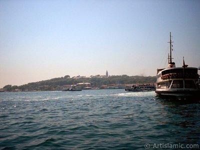 View of a ship waiting at Karakoy jetty and Topkapi Palace from the shore of Karakoy in Istanbul city of Turkey. (The picture was taken by Artislamic.com in 2004.)