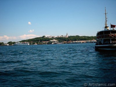 View of a ship waiting at Karakoy jetty and Topkapi Palace from the shore of Karakoy in Istanbul city of Turkey. (The picture was taken by Artislamic.com in 2004.)