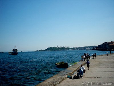 View of fishing people, Sarayburnu coast, Topkapi Palace, Ayasofya Mosque (Hagia Sophia) and Sultan Ahmet Mosque (Blue Mosque) from a park at Kabatas shore in Istanbul city of Turkey. (The picture was taken by Artislamic.com in 2004.)