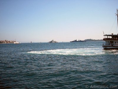 View of a landing ship, on the horizon Kiz Kulesi (Maiden`s Tower), Uskudar coast on the left and Sarayburnu coast on the rigth from the shore of Besiktas in Istanbul city of Turkey. (The picture was taken by Artislamic.com in 2004.)