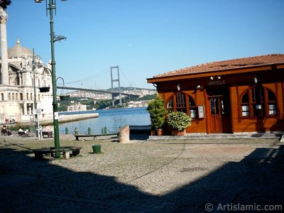 View of the jetty, Bosphorus Bridge, Ortakoy Mosque and the moon seen in daytime over the bridge`s legs from Ortakoy shore in Istanbul city of Turkey. (The picture was taken by Artislamic.com in 2004.)