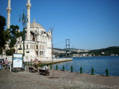 View of Bosphorus Bridge, Ortakoy Mosque and the moon seen in daytime over the bridge`s legs from Ortakoy shore in Istanbul city of Turkey. (The picture was taken by Artislamic.com in 2004.)