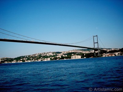 View of Bosphorus Bridge, Camlica Hill, Beylerbeyi coast and the moon seen in daytime over the bridge`s legs from Ortakoy shore in Istanbul city of Turkey. (The picture was taken by Artislamic.com in 2004.)