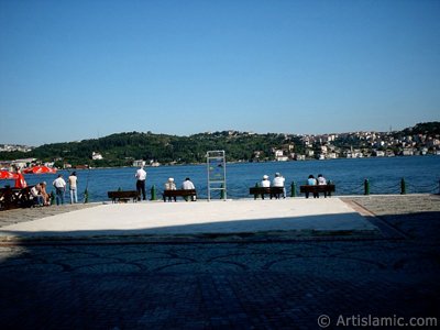 stanbul Ortaky sahilinde bir parkta oturanlar, balk tutanlar ve ufukta skdar-Beylerbeyi srtlar. (Resim 2004 ylnda islamiSanat.net tarafndan ekildi.)