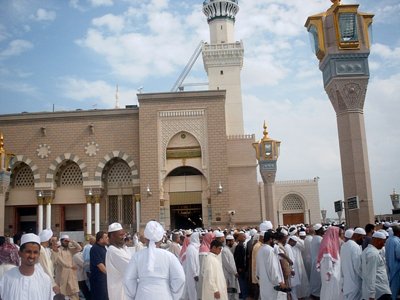 The Prophet Muhammad`s (saaw) Mosque (Masjed an-Nabawe) in Madina city of Saudi Arabia and the muslims going out of mosque after a prayer time. When you go in the door in the middle and go straight you reach the minbar, home and tomb of the Prophet Muhammad (saaw). (The picture was taken by Mr. Mustafa one of the visitors of Artislamic.com in 2003 Ramadan.)