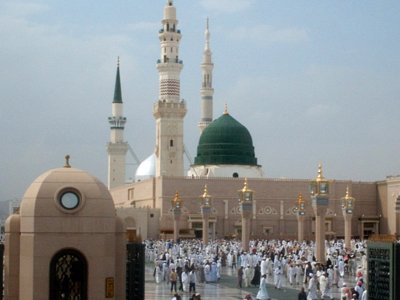 The Prophet Muhammad`s (saaw) Mosque (Masjed an-Nabawe) in Madina city of Saudi Arabia and the muslims going out of mosque after a prayer time. On the area under the green dome there are tombs of the Prophet Muhammad, Abubakr (first caliph of Islam) and Omar (second caliph). At the same time there is home and minbar of the Prophet and ``soffa`` where the poor muslims used to stay and take education in the time of the Prophet. (The picture was taken by Mr. Mustafa one of the visitors of Artislamic.com in 2003 Ramadan.)