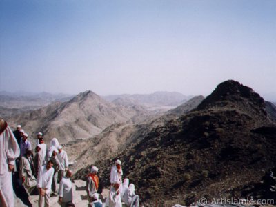 View of the peak of the Mount Hira and the pilgrims climbed to the mount. Before the Prophet Muhammad (saaw) was charged with the prophethood by Allah (swt) he would go for spiritual retreats to a cave called as Cave Hira in this mount. The Prophet Muhammad had received the first Koran verses from our Lord in the Cave Hira on this mount and seen the Angel Gabriel first time in its true form here. The first Koran verses revealed to Him on this mount were these: ``READ! IN THE NAME OF YOUR LORD WHO CREATES. CREATES MAN FROM A CLOT OF BLOOD. READ! AND YOUR LORD IS MOST GENEROUS. WHO TEACHES BY THE PEN. TEACHES MEN THAT WHICH HE KNEW NOT.`` (The Holy Koran: 96:1-5.) (The picture was taken by Mr. Mustafa one of the visitors of Artislamic.com in 2003 Hajj season.)