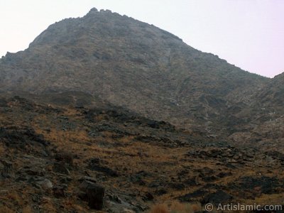 The Mount Savr in Mecca city of Saudi Arabia. The Prophet Muhammed (saaw) and his friend Abu Bakr (ra) had got shut of the Meccan enemies tracking them by hidding three days in a cave in this mount with the great help of Allah (swt). In the Holy Koran our Lord Allah said about the Savr Cave in this mount: ``If ye help not (Muhammad), (it is no matter): for Allah did indeed help him, when the unbelievers drove him out: he had no more than one companion: they two were in the Cave, and he said to his companion, ``Have no fear for Allah is with us``: then Allah sent down His peace upon him, and strengthened him with forces which ye saw not, and humbled to the depths the word of the unbelievers. But the word of Allah is exalted to the heights: for Allah is Exalted in might, Wise.`` (The Holy Koran 9:40). (The picture was taken by Mr. Mustafa one of the visitors of Artislamic.com in 2003 Ramadan.)