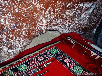 View of the inside of the Cave Savr on Mount Savr in Mecca city of Saudi Arabia.The Prophet Muhammed (saaw) and his friend Abu Bakr (ra) had got shut of the Meccan enemies tracking them by hidding three days in this cave with the great help of Allah (swt). Once the unbelieving enemies had come to the entrance of the cave but they returned without entering it. When the sound of their retreating steps and voices had died away, the Prophet and Abu Bakr went to the mouth of the cave. There over the entrance a spider had woven its web. They looked through the web, and there in the hollow of a rock, even where a man might step as he entered the cave, a rock dove had made a nesting place and was sitting close as if she had eggs, with her mate perched on a ledge not for above. (Sources: Le Prophte de l`Islam, Muhammad Hamidullah; The Life Of Prophet, Abubakr Seracudden [Martin Lings], The Hijrah). In the Holy Koran our Lord Allah said about the Savr Cave: ``If ye help not (Muhammad), (it is no matter): for Allah did indeed help him, when the unbelievers drove him out: he had no more than one companion: they two were in the Cave, and he said to his companion, ``Have no fear for Allah is with us``: then Allah sent down His peace upon him, and strengthened him with forces which ye saw not, and humbled to the depths the word of the unbelievers. But the word of Allah is exalted to the heights: for Allah is Exalted in might, Wise.`` (The Holy Koran 9:40). (The picture was taken by Mr. Mustafa one of the visitors of Artislamic.com in 2003 Ramadan.)