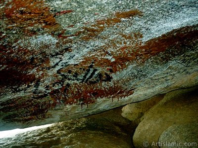 Picture of the ceiling of the Cave Savr on Mount Savr in Mecca city of Saudi Arabia. taken by sitting in it. The Prophet Muhammed (saaw) and his friend Abu Bakr (ra) had got shut of the Meccan enemies tracking them by hidding three days in this cave with the great help of Allah (swt). Once the unbelieving enemies had come to the entrance of the cave but they returned without entering it. When the sound of their retreating steps and voices had died away, the Prophet and Abu Bakr went to the mouth of the cave. There over the entrance a spider had woven its web. They looked through the web, and there in the hollow of a rock, even where a man might step as he entered the cave, a rock dove had made a nesting place and was sitting close as if she had eggs, with her mate perched on a ledge not for above. (Sources: Le Prophte de l`Islam, Muhammad Hamidullah; The Life Of Prophet, Abubakr Seracudden [Martin Lings], The Hijrah). In the Holy Koran our Lord Allah said about the Savr Cave: ``If ye help not (Muhammad), (it is no matter): for Allah did indeed help him, when the unbelievers drove him out: he had no more than one companion: they two were in the Cave, and he said to his companion, ``Have no fear for Allah is with us``: then Allah sent down His peace upon him, and strengthened him with forces which ye saw not, and humbled to the depths the word of the unbelievers. But the word of Allah is exalted to the heights: for Allah is Exalted in might, Wise.`` (The Holy Koran 9:40). (The picture was taken by Mr. Mustafa one of the visitors of Artislamic.com in 2003 Ramadan.)