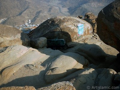 View of the upper entrance of the Cave Savr on Mount Savr in Mecca city of Saudi Arabia. The Prophet Muhammed (saaw) and his friend Abu Bakr (ra) had got shut of the Meccan enemies tracking them by hidding three days in this cave with the great help of Allah (swt). Once the unbelieving enemies had come to the entrance of the cave but they returned without entering it. When the sound of their retreating steps and voices had died away, the Prophet and Abu Bakr went to the mouth of the cave. There over the entrance a spider had woven its web. They looked through the web, and there in the hollow of a rock, even where a man might step as he entered the cave, a rock dove had made a nesting place and was sitting close as if she had eggs, with her mate perched on a ledge not for above. (Sources: Le Prophte de l`Islam, Muhammad Hamidullah; The Life Of Prophet, Abubakr Seracudden [Martin Lings], The Hijrah). In the Holy Koran our Lord Allah said about the Savr Cave: ``If ye help not (Muhammad), (it is no matter): for Allah did indeed help him, when the unbelievers drove him out: he had no more than one companion: they two were in the Cave, and he said to his companion, ``Have no fear for Allah is with us``: then Allah sent down His peace upon him, and strengthened him with forces which ye saw not, and humbled to the depths the word of the unbelievers. But the word of Allah is exalted to the heights: for Allah is Exalted in might, Wise.`` (The Holy Koran 9:40). (The picture was taken by Mr. Mustafa one of the visitors of Artislamic.com in 2003 Ramadan.)