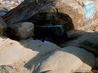 View of the upper entrance of the Cave Savr on Mount Savr in Mecca city of Saudi Arabia. The Prophet Muhammed (saaw) and his friend Abu Bakr (ra) had got shut of the Meccan enemies tracking them by hidding three days in this cave with the great help of Allah (swt). Once the unbelieving enemies had come to the entrance of the cave but they returned without entering it. When the sound of their retreating steps and voices had died away, the Prophet and Abu Bakr went to the mouth of the cave. There over the entrance a spider had woven its web. They looked through the web, and there in the hollow of a rock, even where a man might step as he entered the cave, a rock dove had made a nesting place and was sitting close as if she had eggs, with her mate perched on a ledge not for above. (Sources: Le Prophte de l`Islam, Muhammad Hamidullah; The Life Of Prophet, Abubakr Seracudden [Martin Lings], The Hijrah). In the Holy Koran our Lord Allah said about the Savr Cave: ``If ye help not (Muhammad), (it is no matter): for Allah did indeed help him, when the unbelievers drove him out: he had no more than one companion: they two were in the Cave, and he said to his companion, ``Have no fear for Allah is with us``: then Allah sent down His peace upon him, and strengthened him with forces which ye saw not, and humbled to the depths the word of the unbelievers. But the word of Allah is exalted to the heights: for Allah is Exalted in might, Wise.`` (The Holy Koran 9:40). (The picture was taken by Mr. Mustafa one of the visitors of Artislamic.com in 2003 Ramadan.)