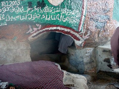 View of the lower entrance of the Cave Savr on Mount Savr in Mecca city of Saudi Arabia. The Prophet Muhammed (saaw) and his friend Abu Bakr (ra) had got shut of the Meccan enemies tracking them by hidding three days in this cave with the great help of Allah (swt). Once the unbelieving enemies had come to the entrance of the cave but they returned without entering it. When the sound of their retreating steps and voices had died away, the Prophet and Abu Bakr went to the mouth of the cave. There over the entrance a spider had woven its web. They looked through the web, and there in the hollow of a rock, even where a man might step as he entered the cave, a rock dove had made a nesting place and was sitting close as if she had eggs, with her mate perched on a ledge not for above. (Sources: Le Prophte de l`Islam, Muhammad Hamidullah; The Life Of Prophet, Abubakr Seracudden [Martin Lings], The Hijrah). In the Holy Koran our Lord Allah said about the Savr Cave: ``If ye help not (Muhammad), (it is no matter): for Allah did indeed help him, when the unbelievers drove him out: he had no more than one companion: they two were in the Cave, and he said to his companion, ``Have no fear for Allah is with us``: then Allah sent down His peace upon him, and strengthened him with forces which ye saw not, and humbled to the depths the word of the unbelievers. But the word of Allah is exalted to the heights: for Allah is Exalted in might, Wise.`` (The Holy Koran 9:40). (The picture was taken by Mr. Mustafa one of the visitors of Artislamic.com in 2003 Ramadan.)