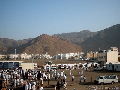 The Mounts Uhud, the field of Battle of Uhud (the second battle of the Prophet Muhammad [saaw] against unbelievers); the cemetery of the first muslims died for Islam during the Battle of Uhud (located in the left) and the pilgrims visiting these places in Mecca city of Saudi Arabia. (The picture was taken by Mr. Mustafa one of the visitors of Artislamic.com in 2003 Ramadan.)