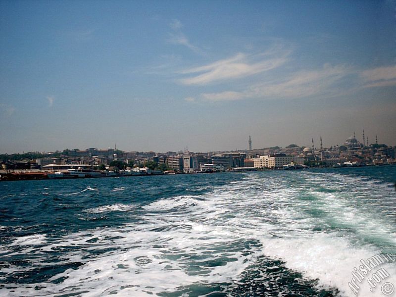 View of Eminonu coast, Beyazit Tower, Yeni Cami (Mosque) and Suleymaniye Mosque from the sea in Istanbul city of Turkey.
